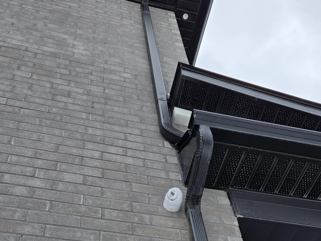 Security camera installed on brick beside a downspout at a Markham home